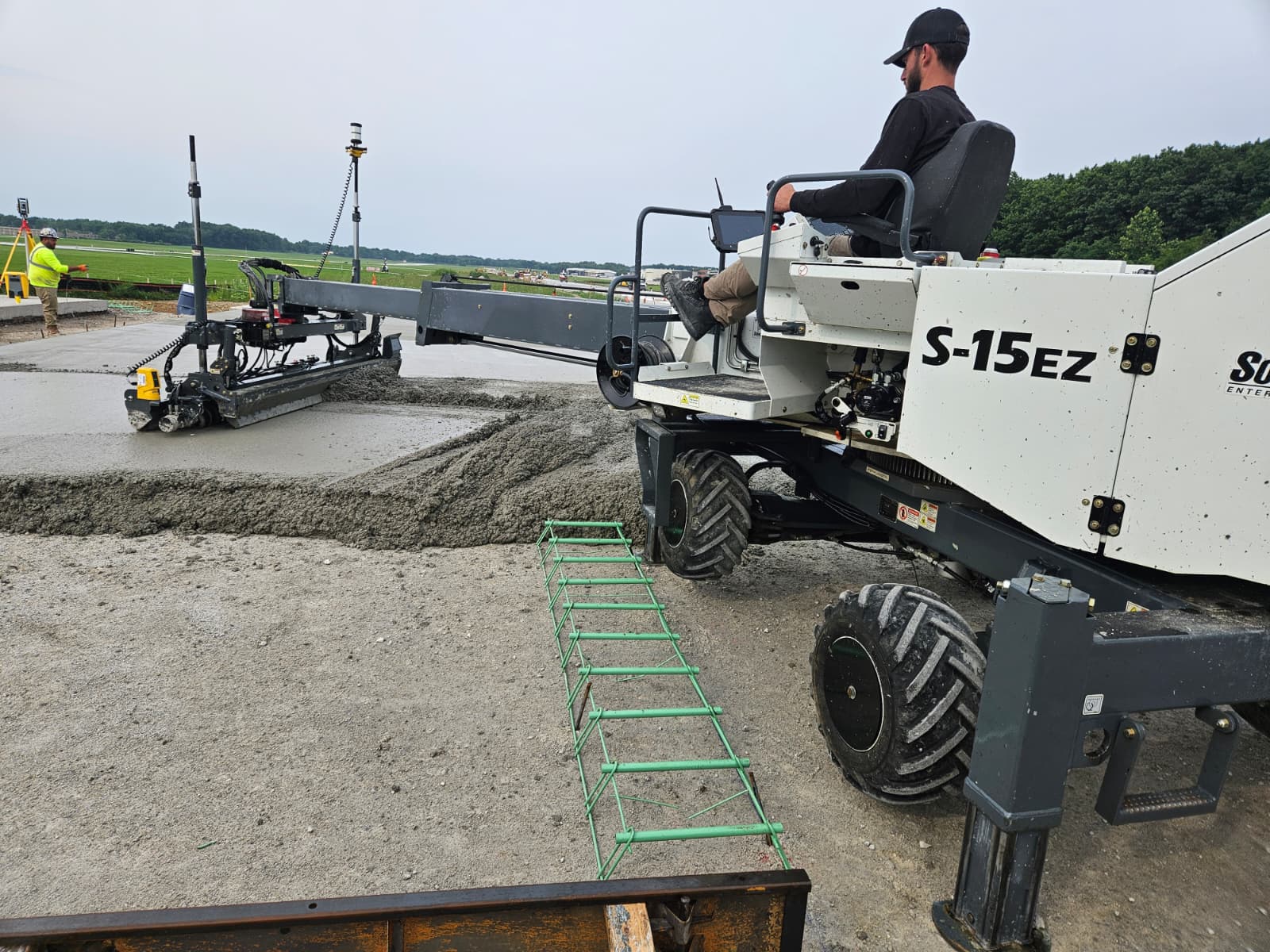 Somero S-15EZ 3D laser screed placing concrete beside an airfield runway