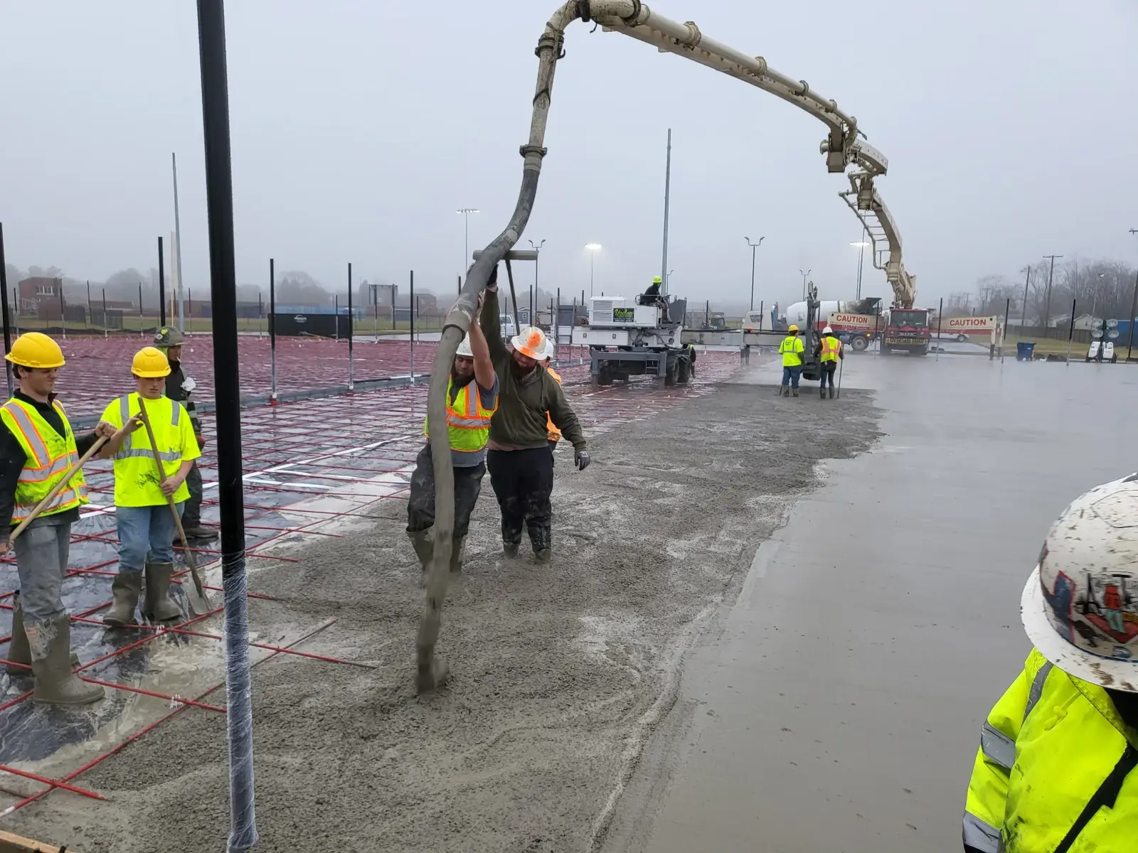 Yoder crew placing and screeding a commercial concrete slab from a boom pump