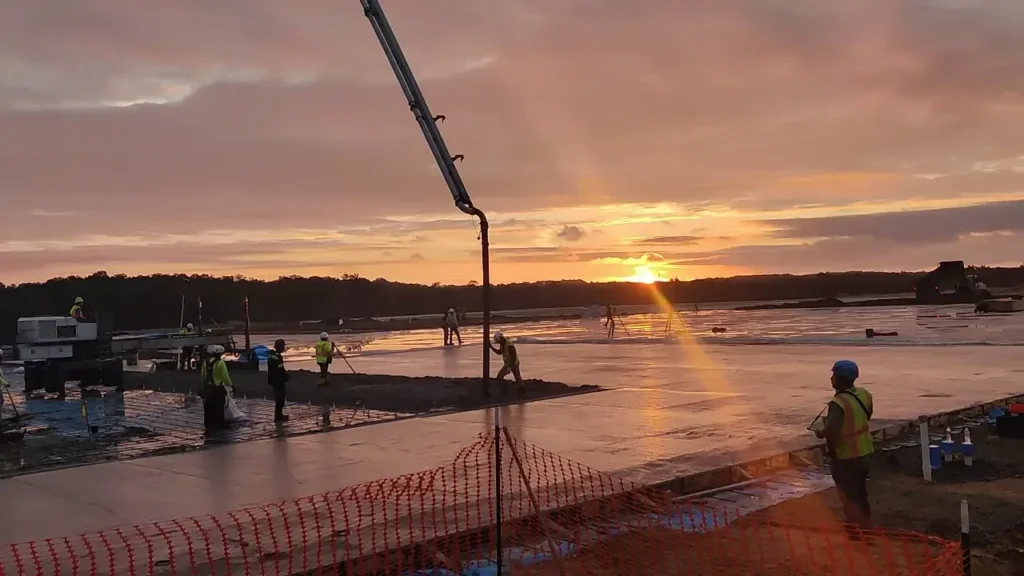 Yoder Laser Concrete crew pouring the 800,000 sq ft Amazon fulfillment center floor at sunset