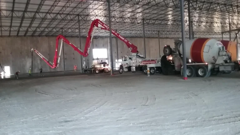 Boom pump placing concrete on an interior slab inside a commercial building