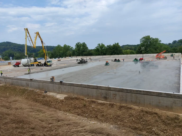Wide commercial slab poured on a raised foundation with boom pumps on site