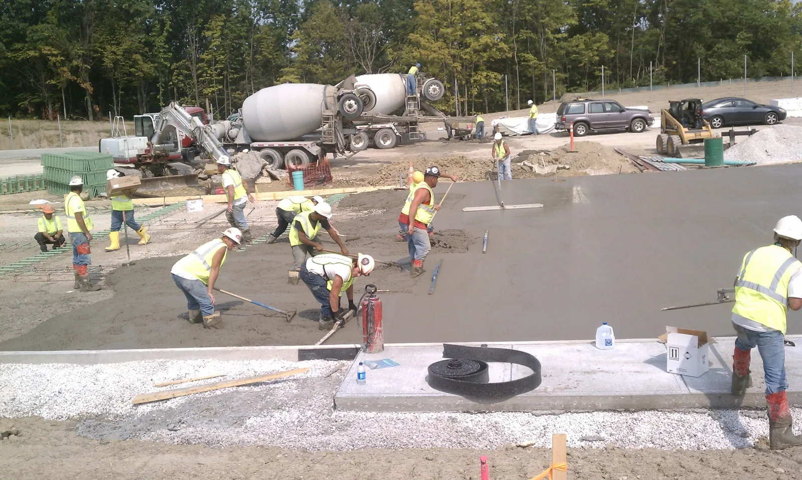 Yoder Laser Concrete crew placing and finishing a commercial slab with a mixer truck alongside