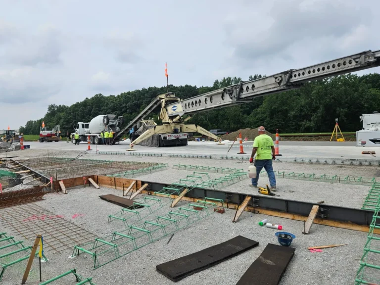 Truck-mounted placing conveyor and crew preparing a slab pour