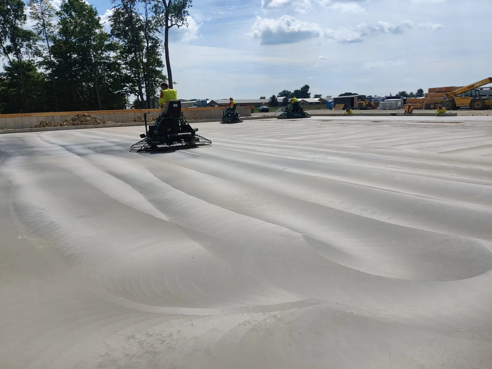 Ride-on power trowel finishing a large commercial warehouse concrete slab