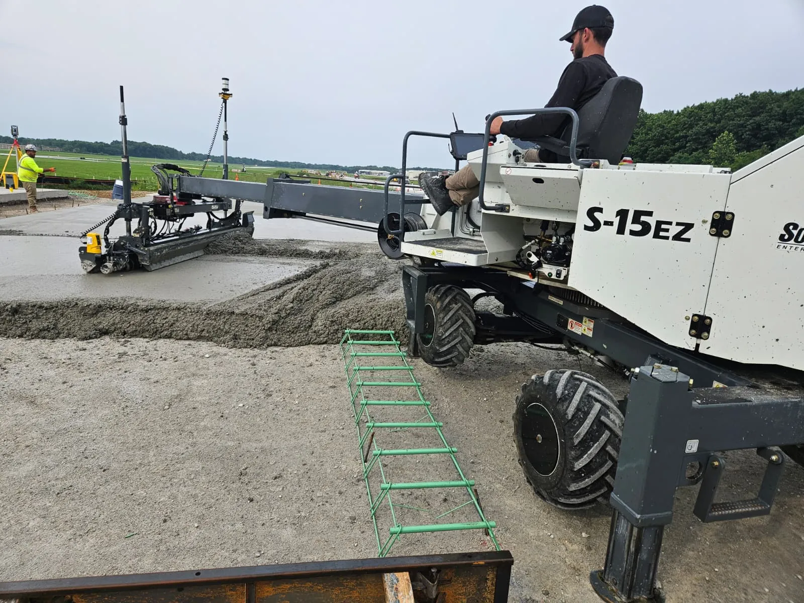 Somero S-15EZ 3D laser screed placing concrete beside an airfield runway